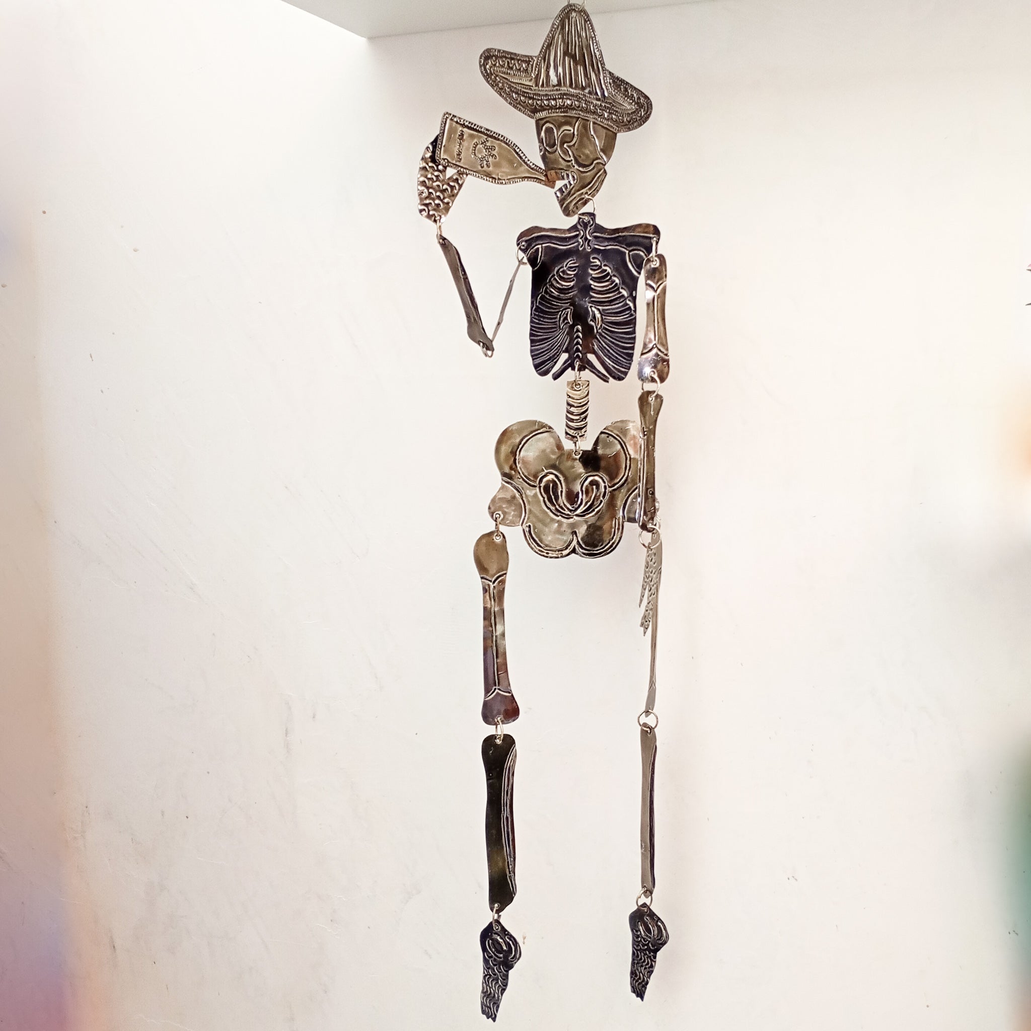 Calavera articulada de hojalata con cerveza