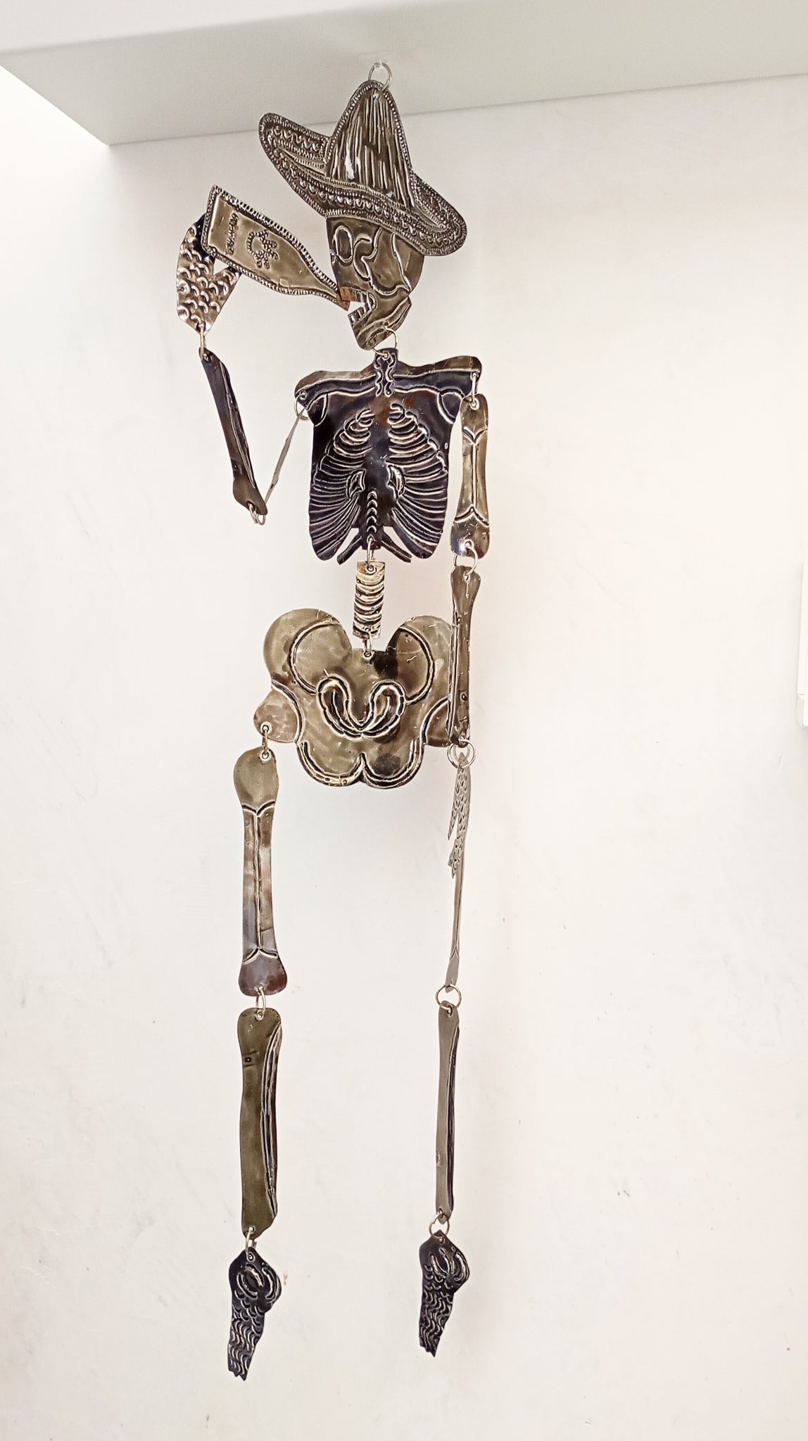 Calavera articulada de hojalata con cerveza