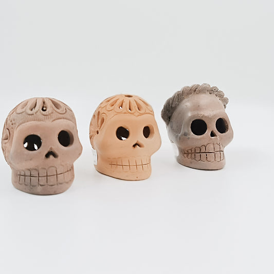 Cráneos de calaverita en barro negro