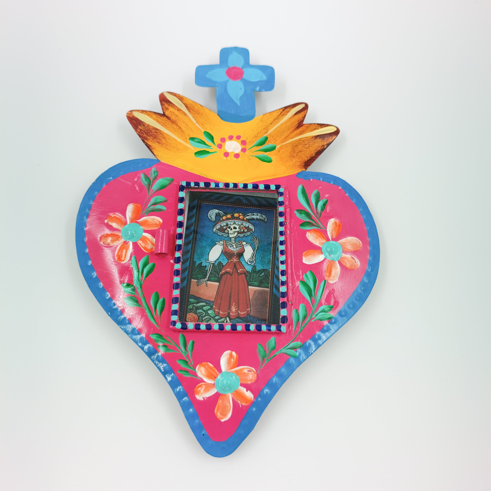 Nicho de corazón de latón con ofrenda de calaveritas