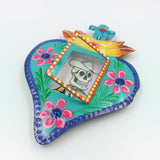 Nicho de corazón de latón con ofrenda de calaveritas