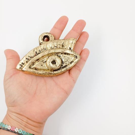 Ojo Milagrito de barro con acabado dorado