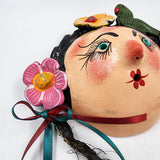 Máscara muñeca con flores hecha de coco