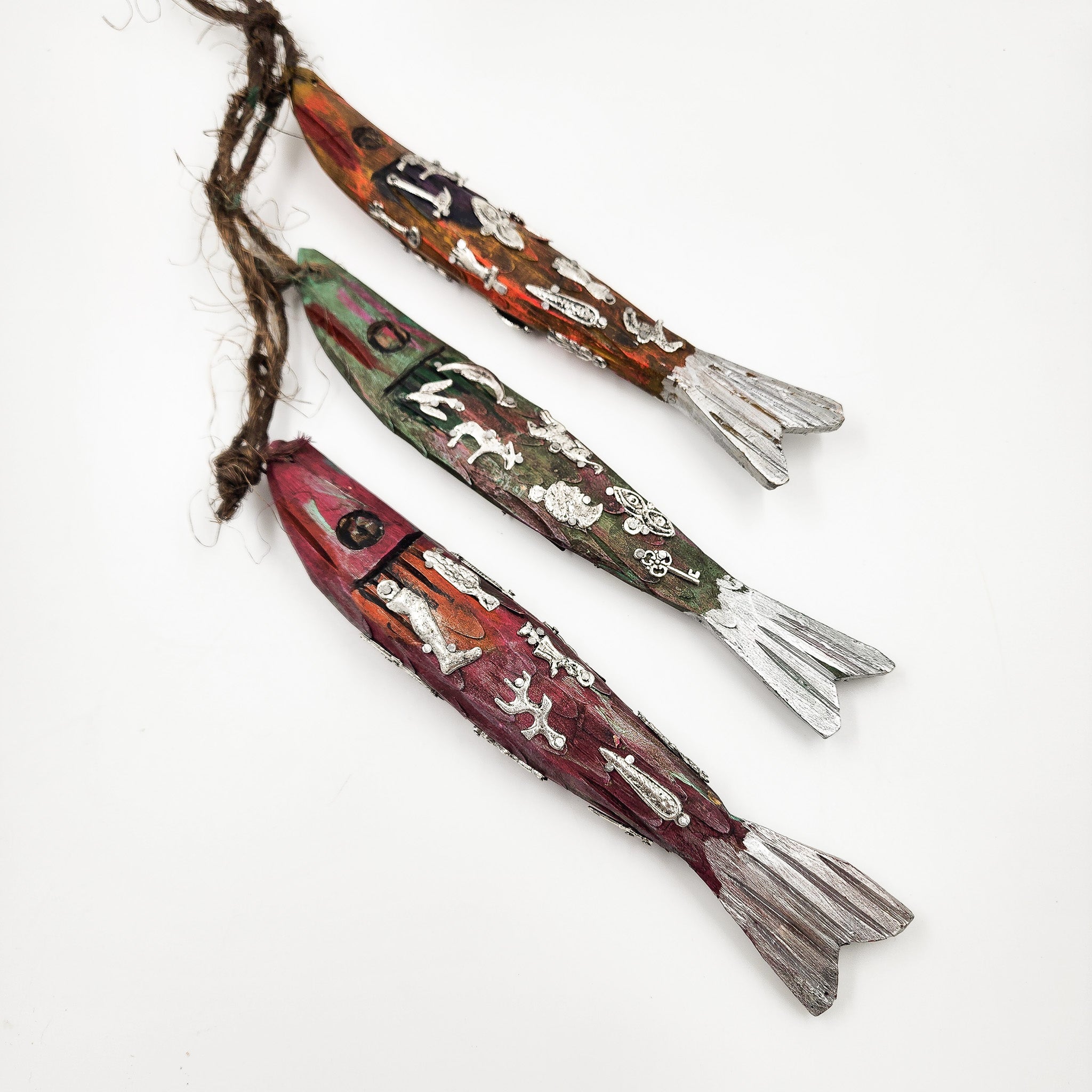 Ristra de peces con milagritos tallados en madera