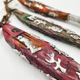 Ristra de peces con milagritos tallados en madera