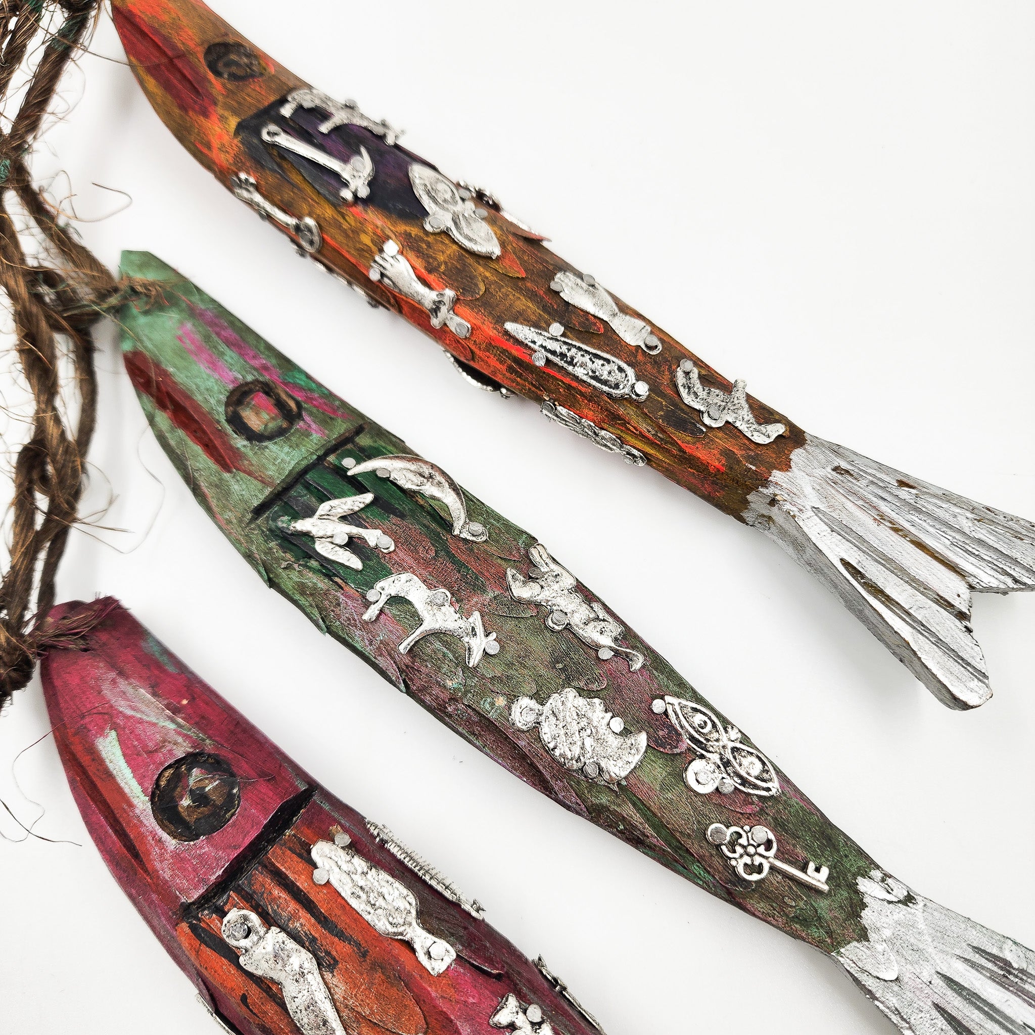 Ristra de peces con milagritos tallados en madera