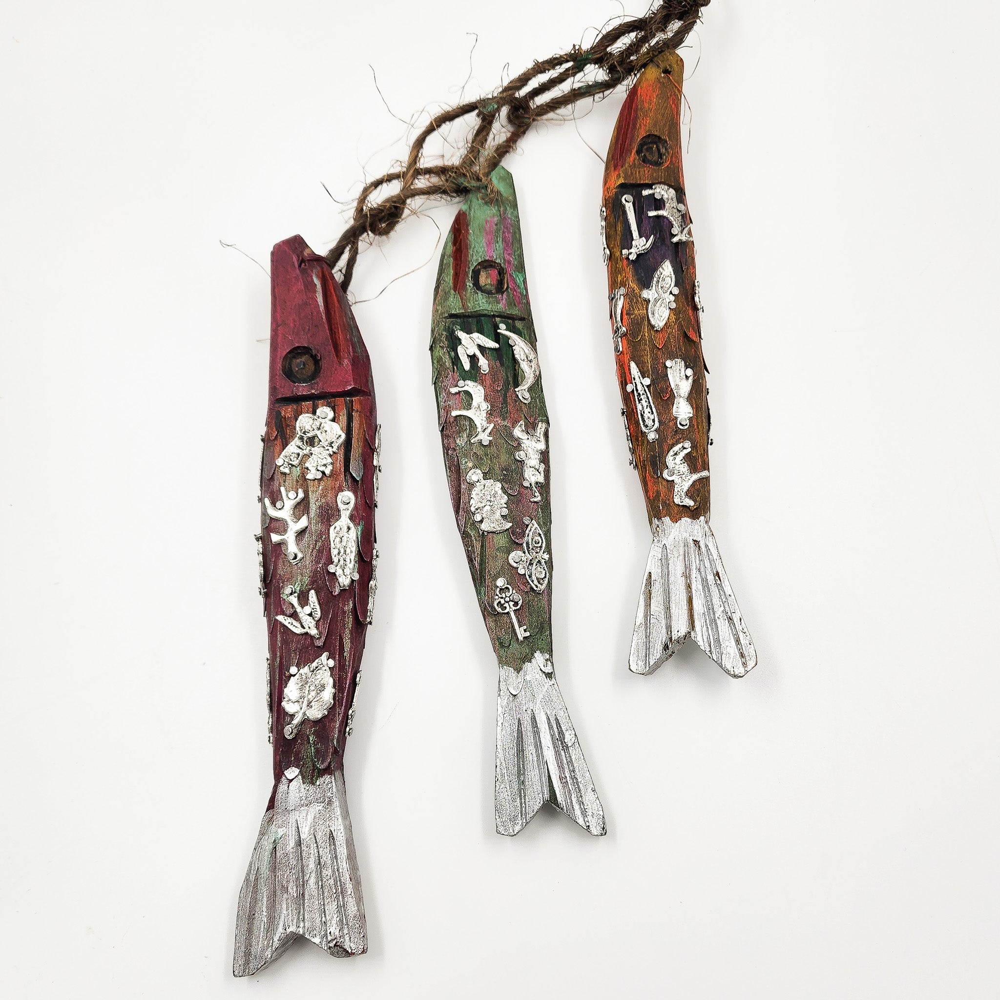 Ristra de peces con milagritos tallados en madera