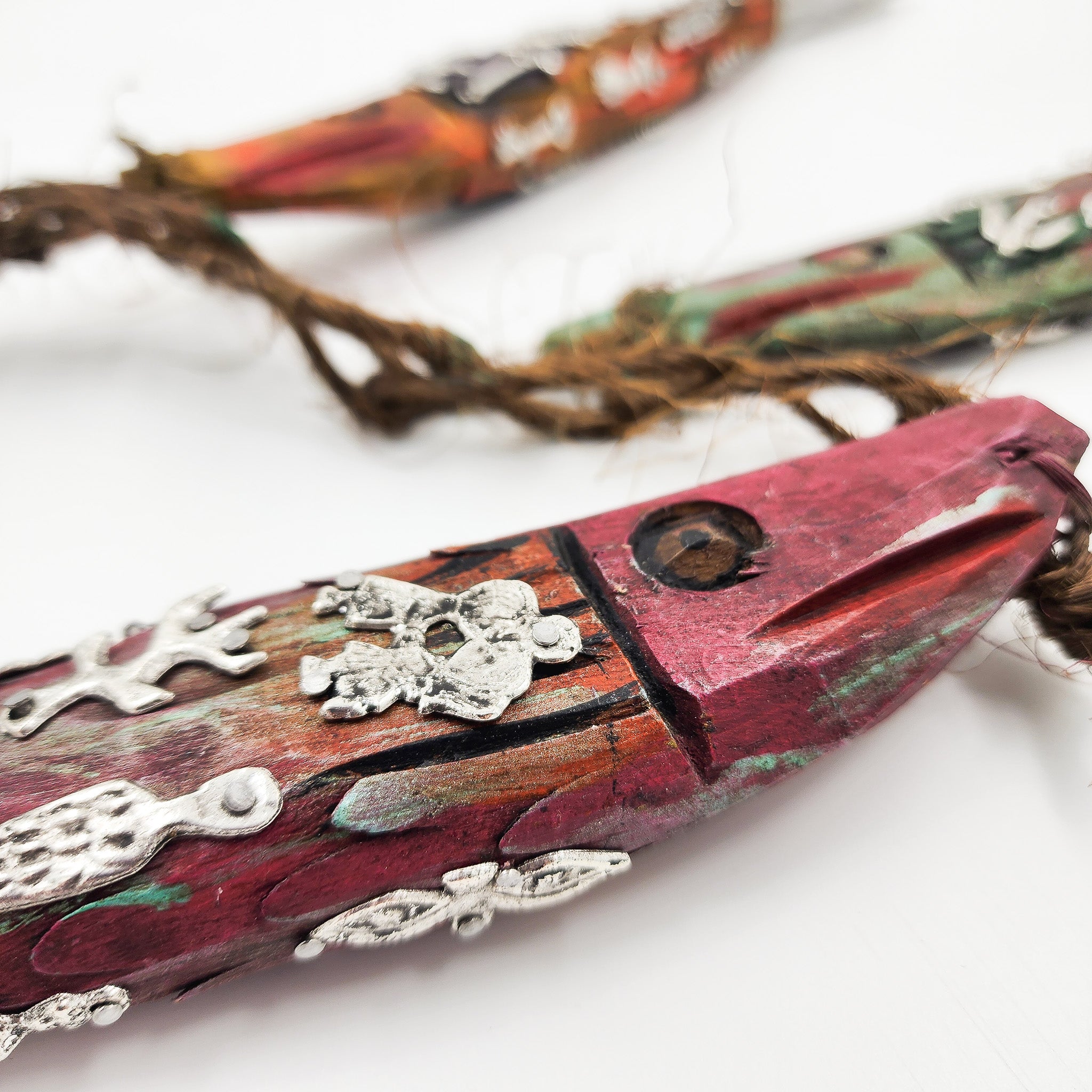 Ristra de peces con milagritos tallados en madera