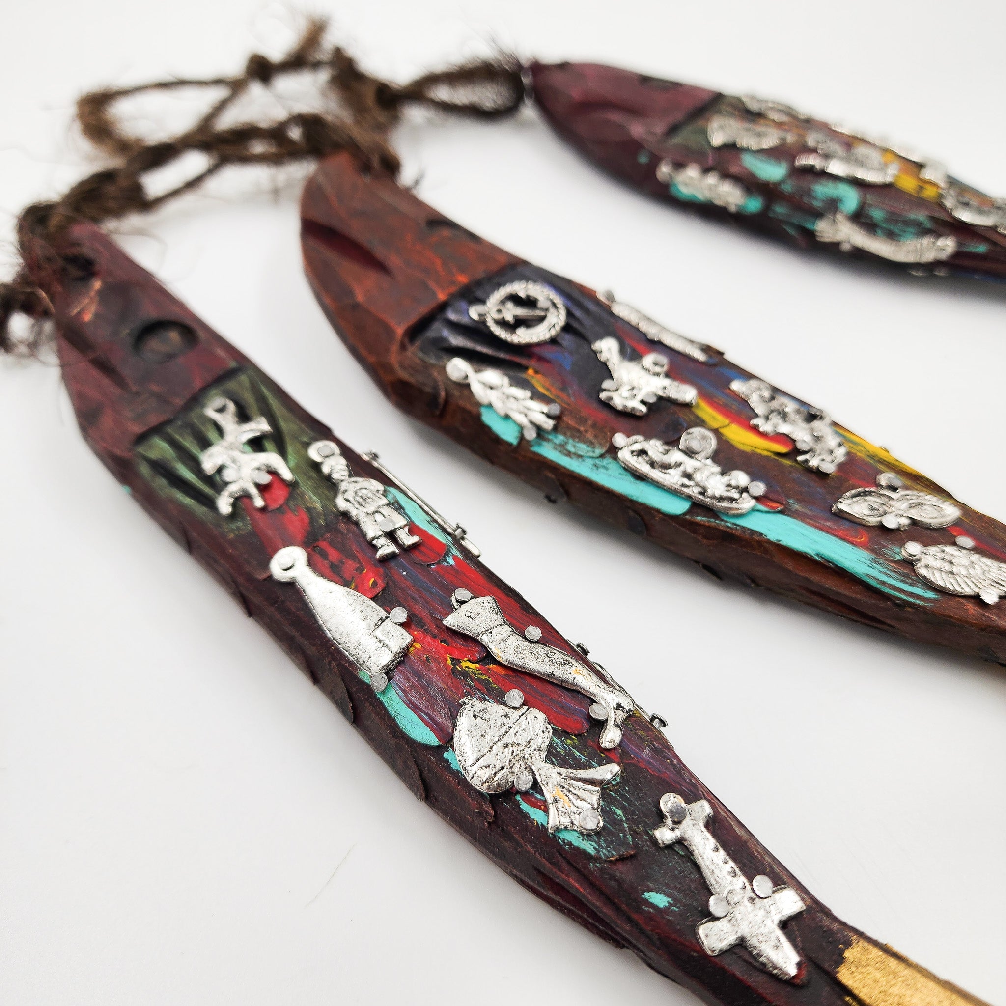 Ristra de peces con milagritos tallados en madera