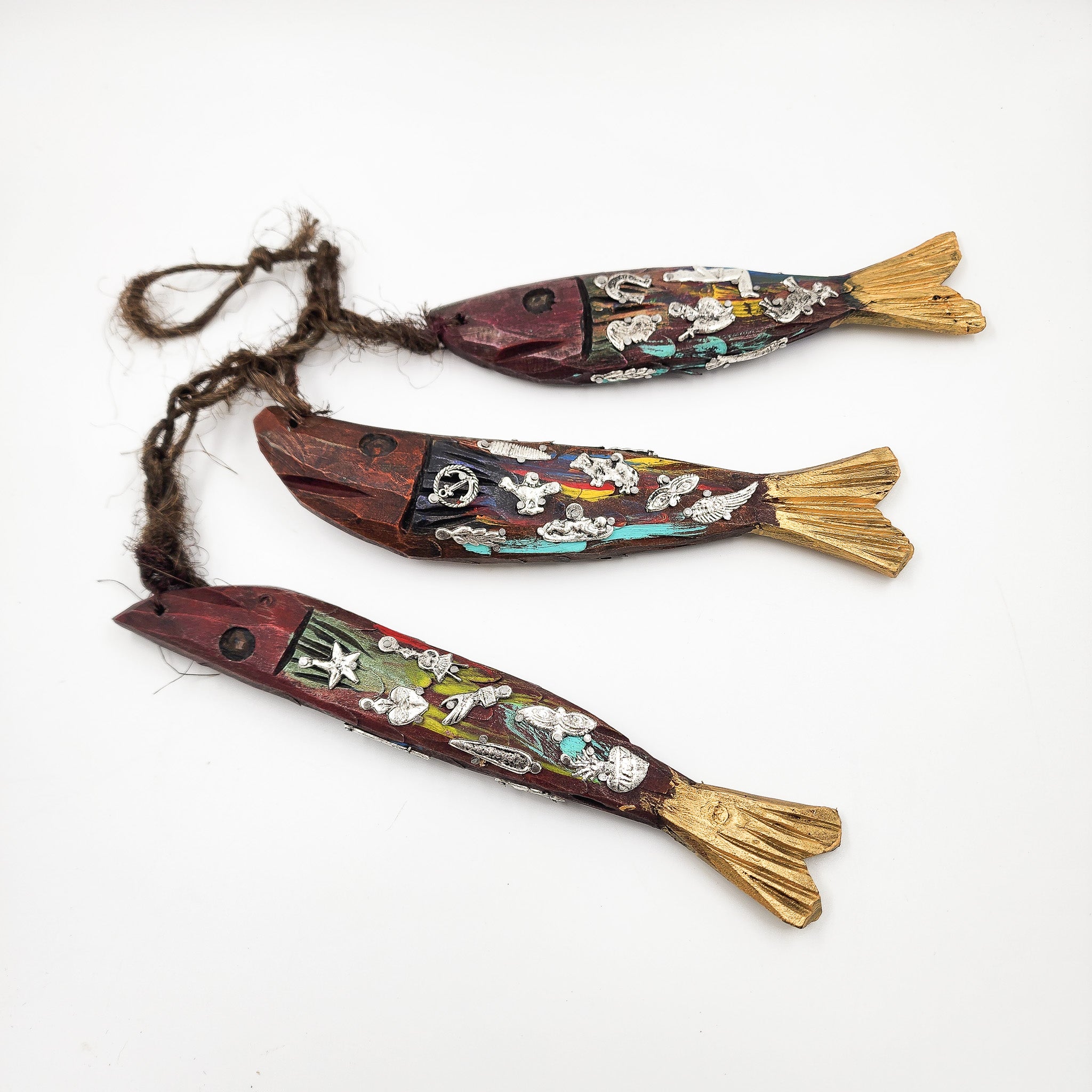 Ristra de peces con milagritos tallados en madera