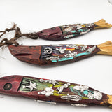 Ristra de peces con milagritos tallados en madera