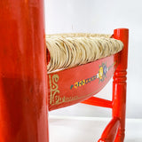 Silla artesanal naranja de madera y palma