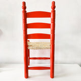 Silla artesanal naranja de madera y palma