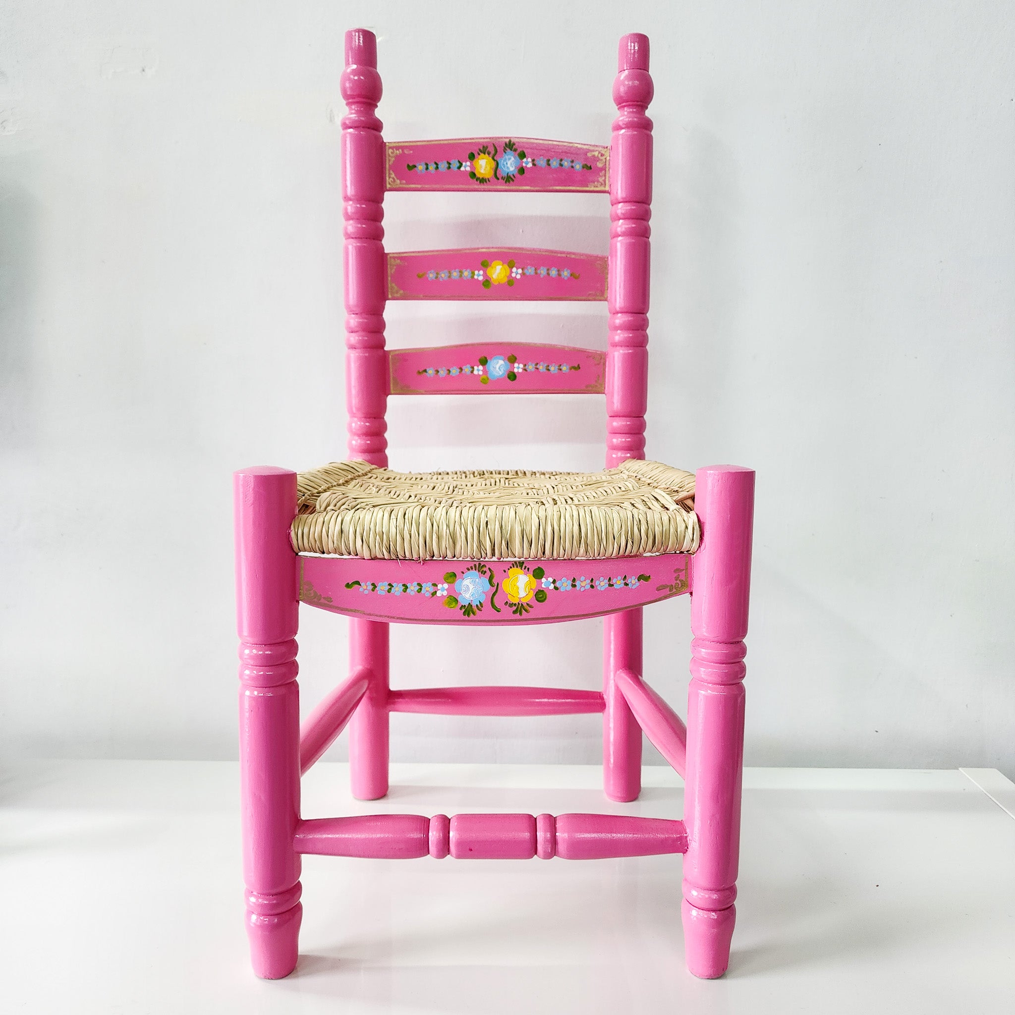 Silla artesanal rosa de madera y palma