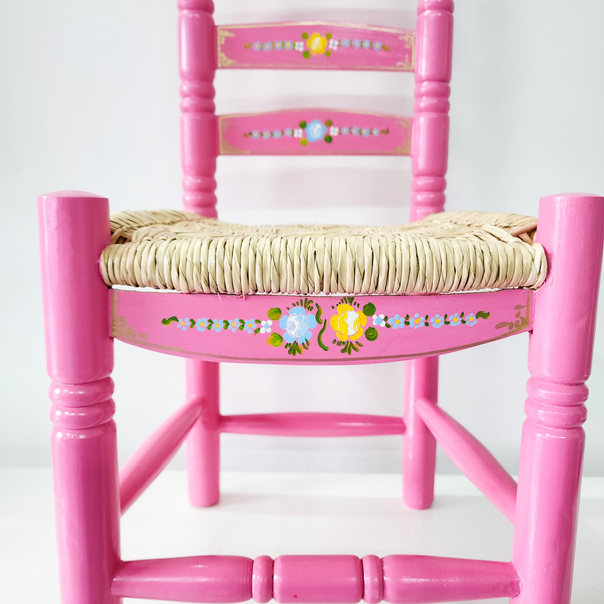 Silla artesanal rosa de madera y palma