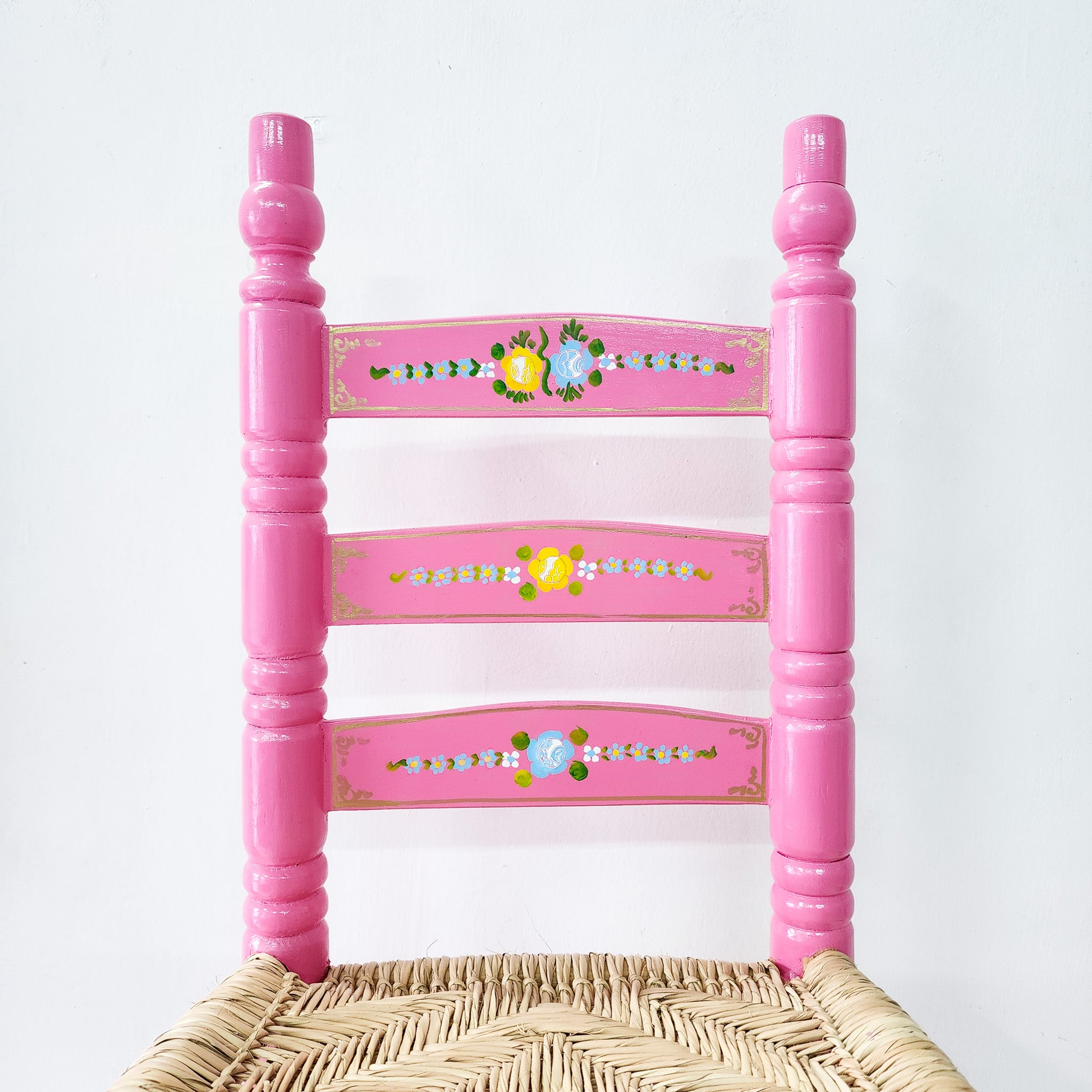 Silla artesanal rosa de madera y palma