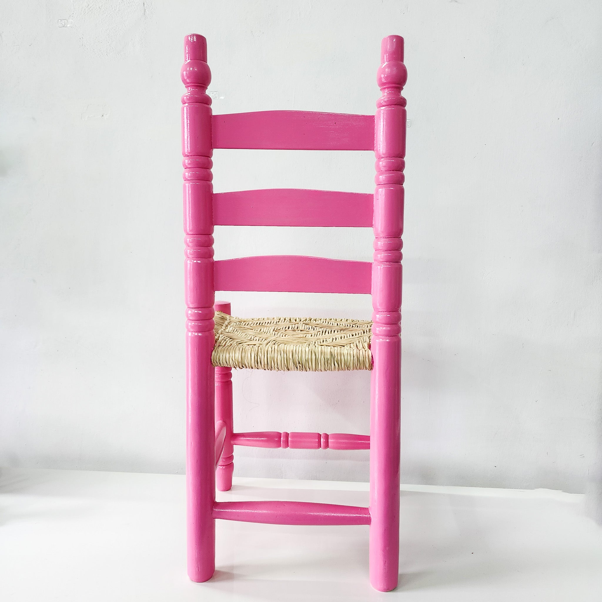 Silla artesanal rosa de madera y palma